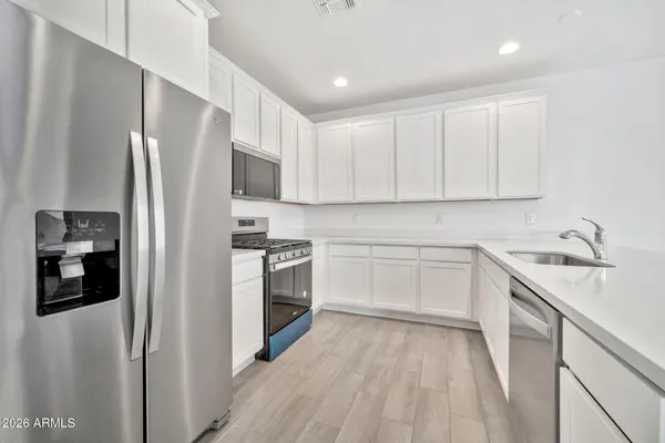 a kitchen with stainless steel appliances granite countertop a refrigerator sink and stove