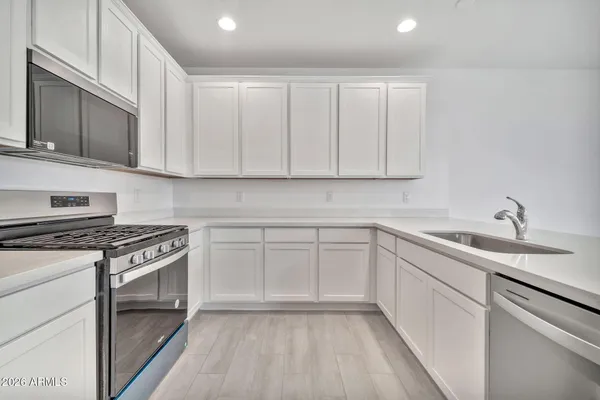 a kitchen with cabinets appliances and a sink