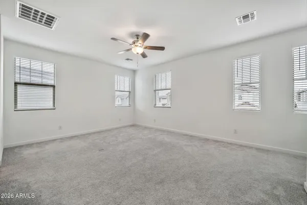 a view of an empty room with a chandelier fan