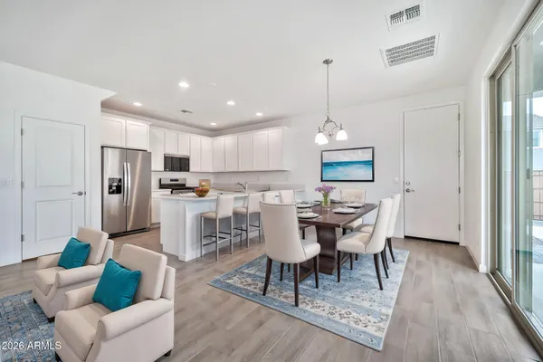 a dining room with furniture a chandelier and wooden floor