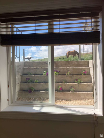7030 West 2100 North Mendon, UT 84325 - Photo 61 of 67 Window with wood-finish blinds and a terraced window well featuring flowering plants