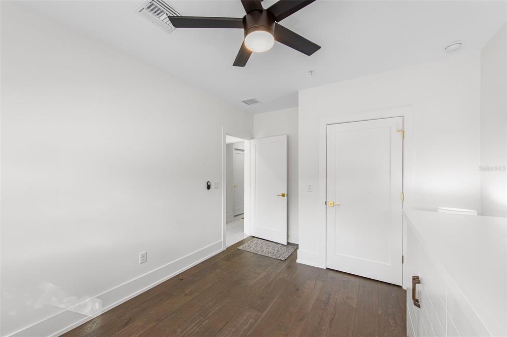 2187 Main Street Sarasota, FL 34237 - Photo 9 of 46 an empty room with wooden floor and ceiling fan