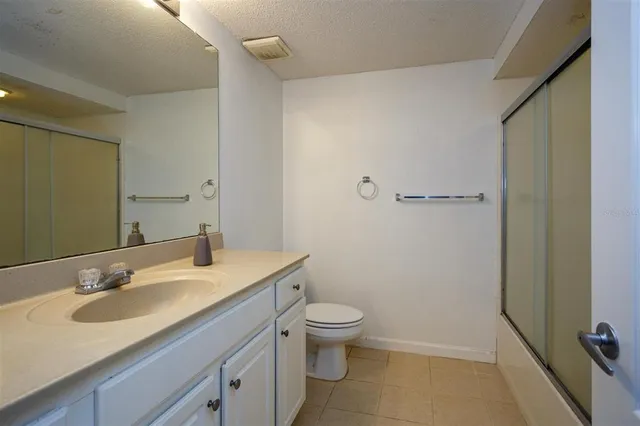 a bathroom with a granite countertop sink toilet and a mirror