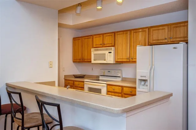 a kitchen with stainless steel appliances a microwave a sink and cabinets