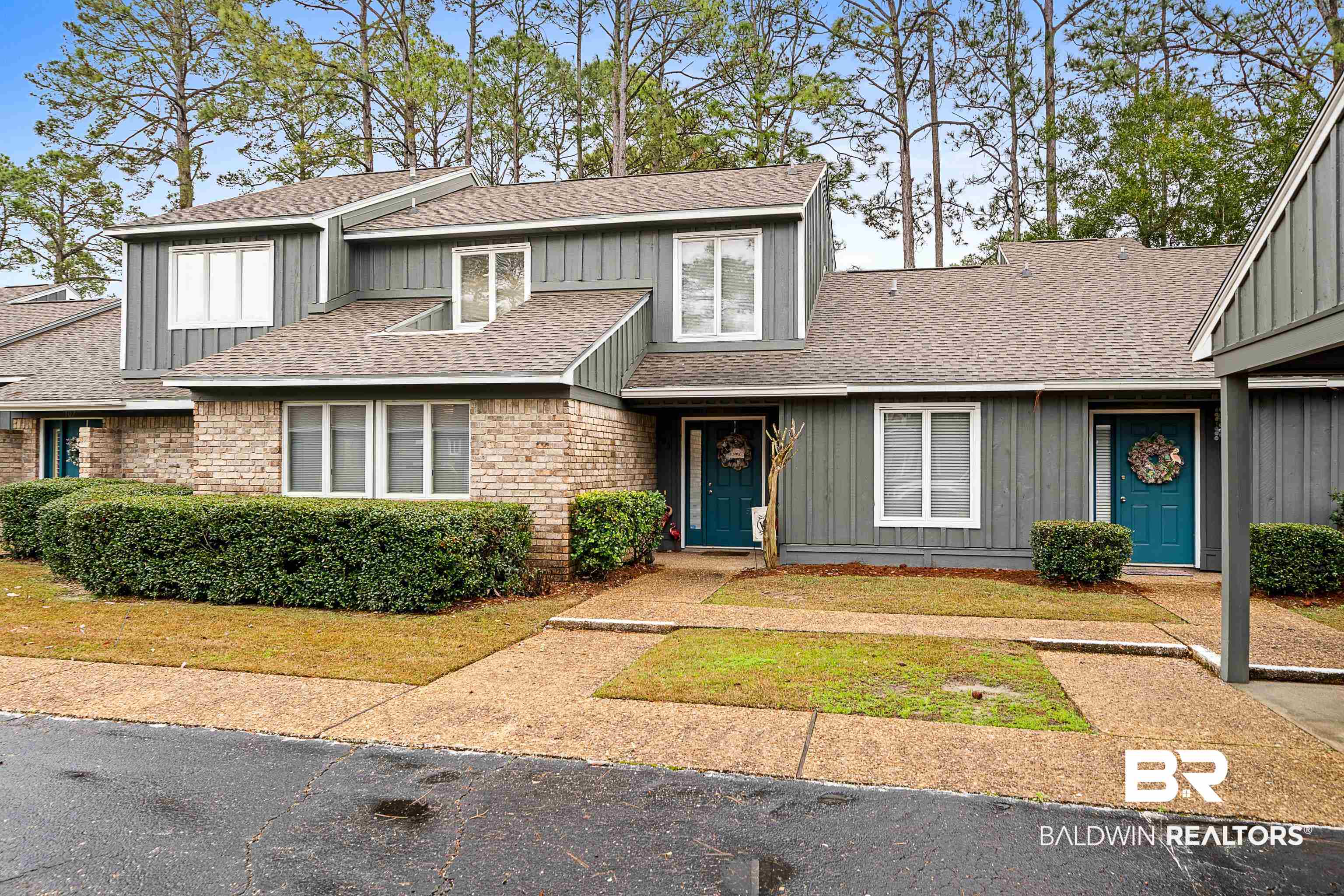 1701 Regency Road, Unit 106 Gulf Shores, AL 36542 - Photo 1 of 42 View of front of house with board and batten siding, a shingled roof, and brick siding