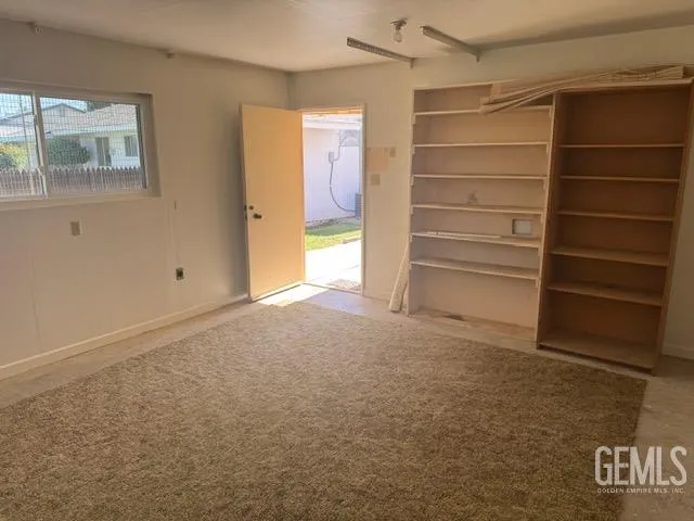 a view of an empty room with a cabinet and a window