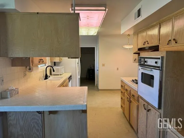 a kitchen with stainless steel appliances a sink a stove and a refrigerator