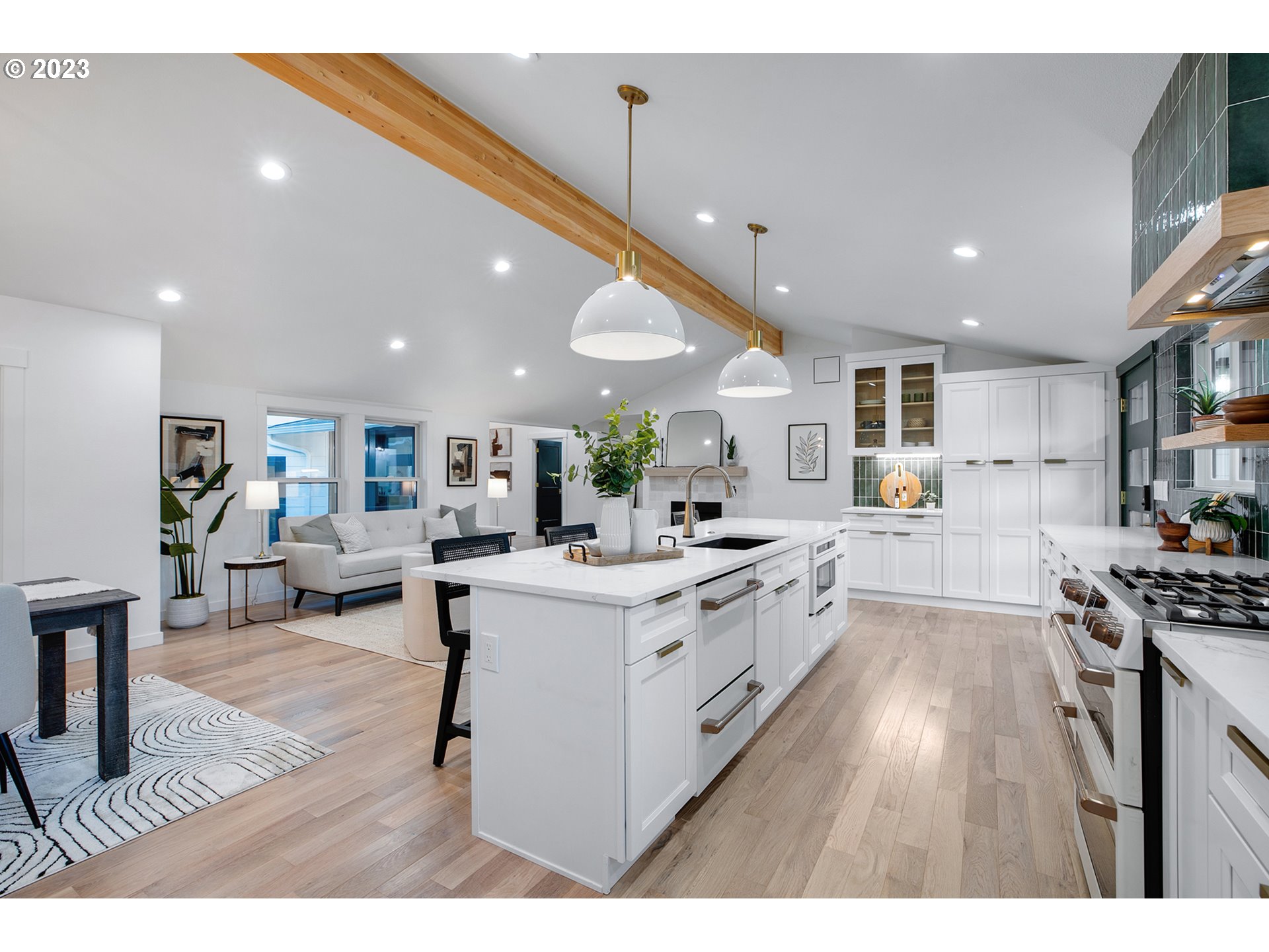 9906 Northwest Leahy Road Portland, OR 97229 - Photo 17 of 36 a kitchen with stainless steel appliances kitchen island wooden floors stove and white cabinets