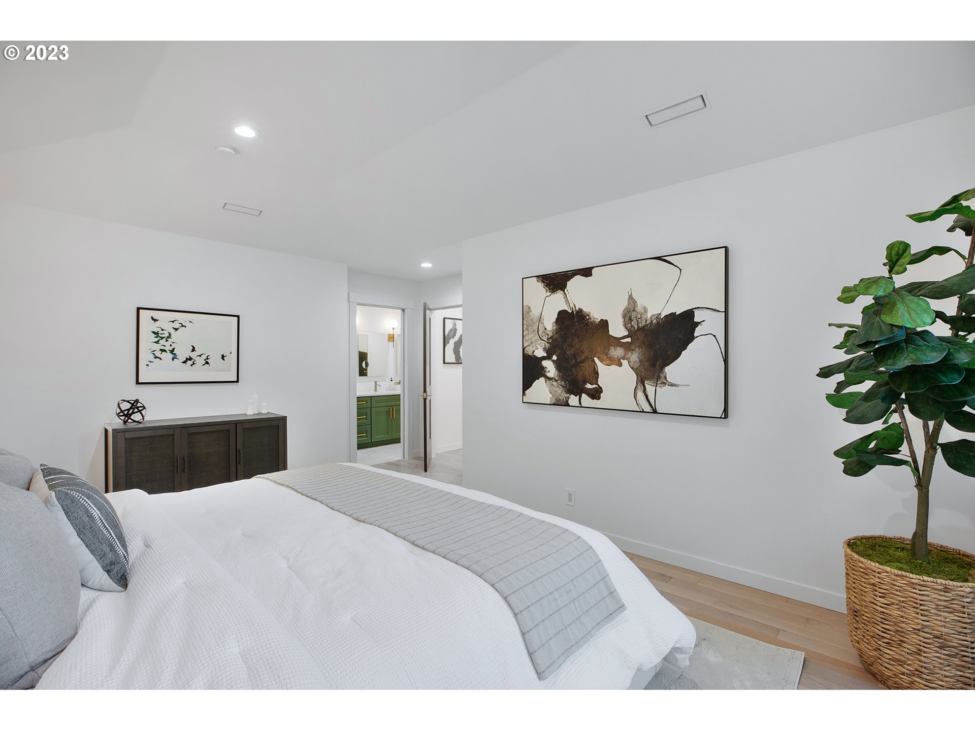 9906 Northwest Leahy Road Portland, OR 97229 - Photo 31 of 36 a bedroom with a large bed and a potted plant