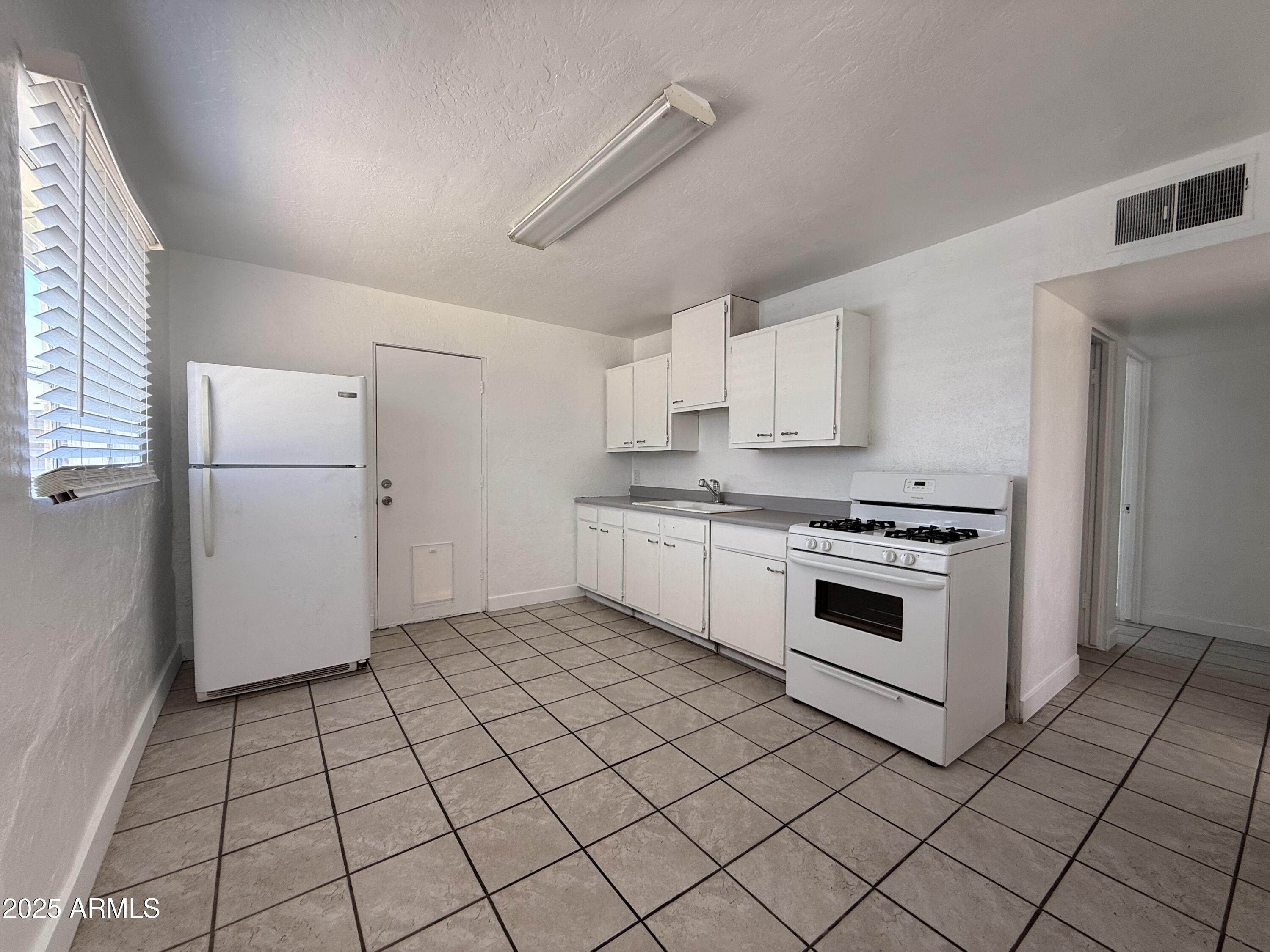 7532 North 21st Avenue, Unit 1 Phoenix, AZ 85021 - Photo 12 of 19 a kitchen with a stove a sink and a refrigerator