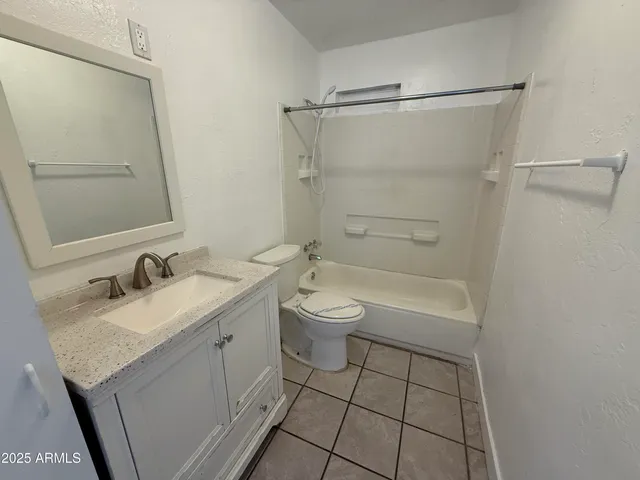 a bathroom with a granite countertop sink a toilet and shower