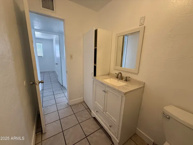 a bathroom with a sink a toilet and mirror