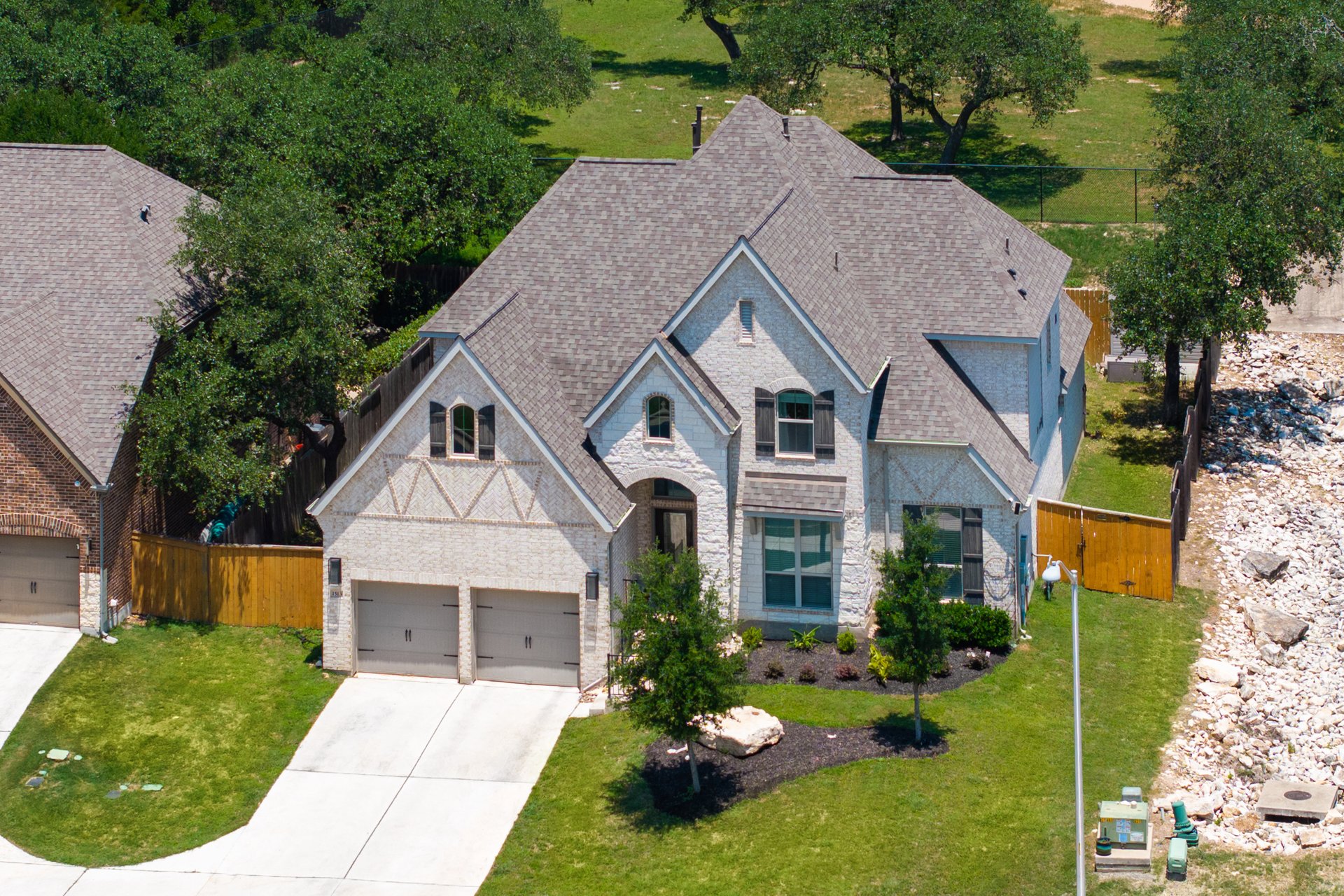 1513 Lakeside Ranch Road Georgetown, TX 78633 - Photo 3 of 40 French country inspired facade featuring a garage, concrete driveway, roof with shingles, stone siding, and brick siding