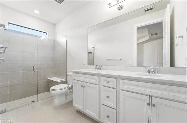 a bathroom with a double vanity sink toilet and shower