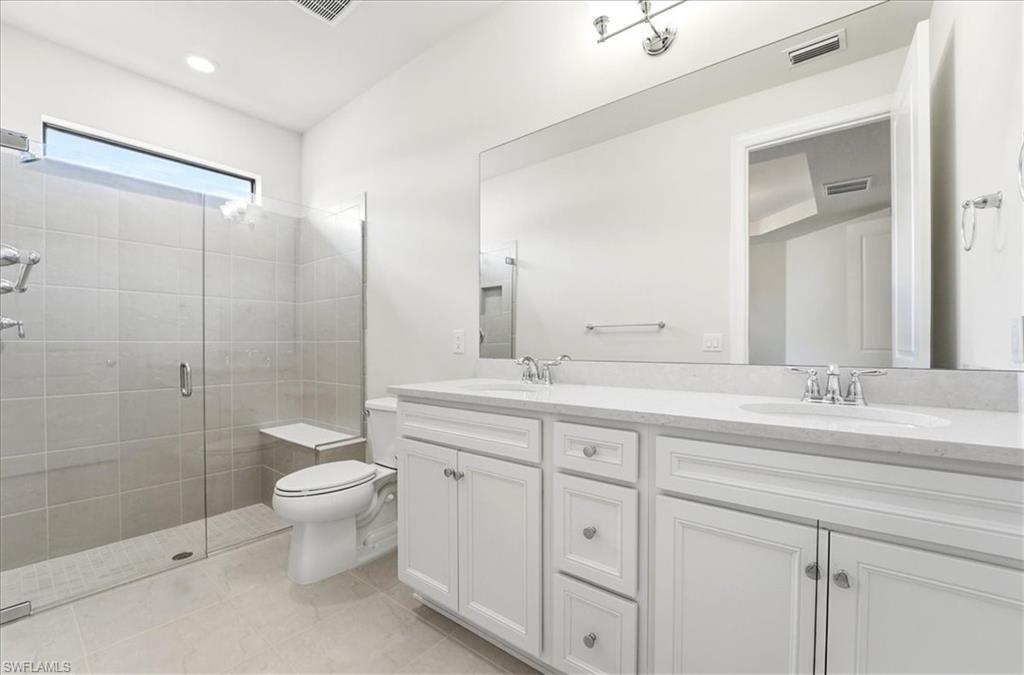 5935 Mayflower Way Ave Maria, FL 34142 - Photo 12 of 36 a bathroom with a double vanity sink toilet and shower