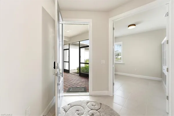 a view of a hallway with wooden floor and a bathroom