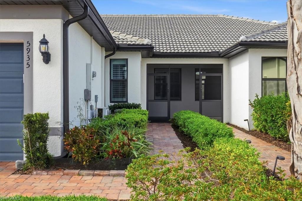 5935 Mayflower Way Ave Maria, FL 34142 - Photo 4 of 36 a view of a house with a large window and flower plants