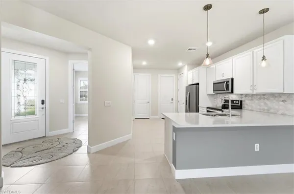 a large kitchen with kitchen island a sink stainless steel appliances and cabinets