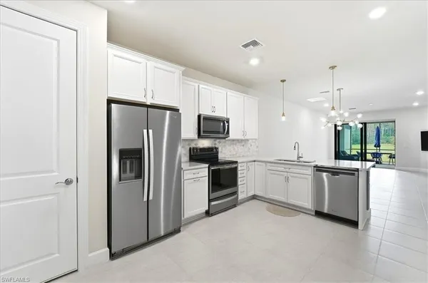 a large kitchen with a refrigerator a stove top oven a sink and dishwasher