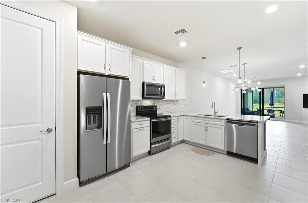 5935 Mayflower Way Ave Maria, FL 34142 - Photo 6 of 36 a large kitchen with a refrigerator a stove top oven a sink and dishwasher