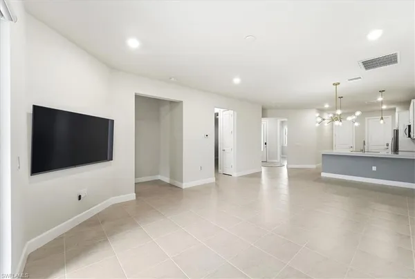 a view of a livingroom with a flat screen tv wooden floor and staircase