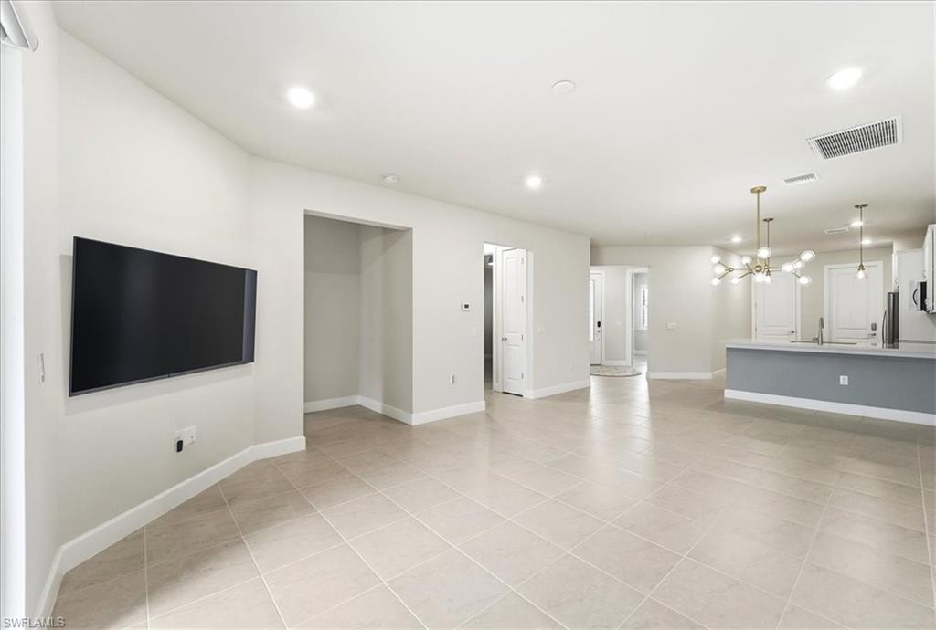 5935 Mayflower Way Ave Maria, FL 34142 - Photo 8 of 36 a view of a livingroom with a flat screen tv wooden floor and staircase