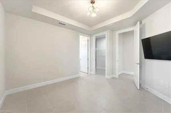 an empty room with chandelier fan