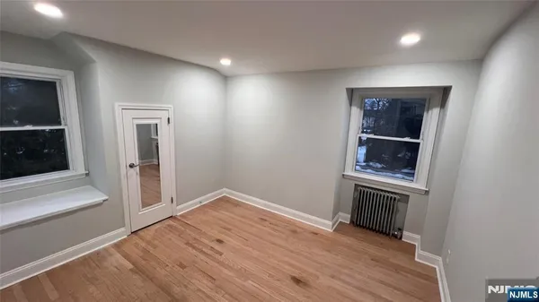 an empty room with wooden floor and entrance