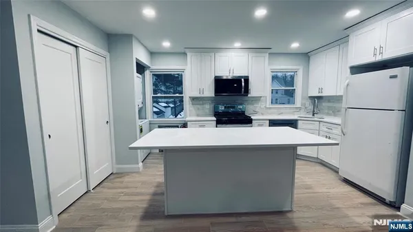 a kitchen with stainless steel appliances a refrigerator and a stove top oven