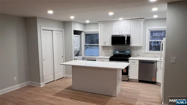 a kitchen with stainless steel appliances a stove top oven a sink a refrigerator and a microwave