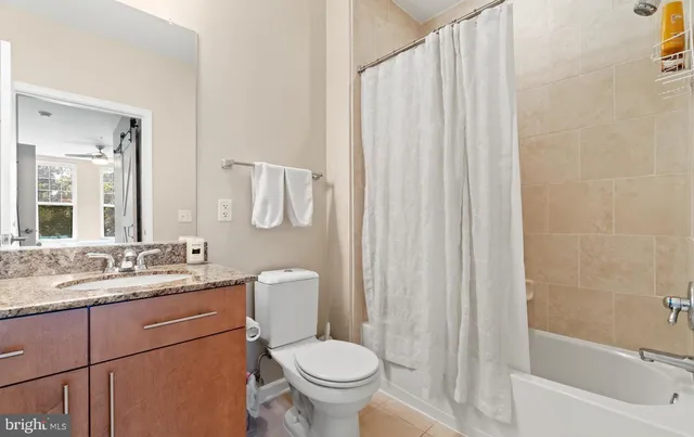 a bathroom with a granite countertop toilet sink and mirror