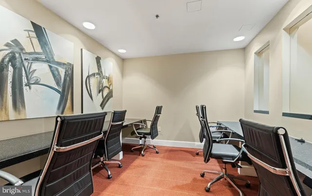 a view of a workspace with furniture and a window