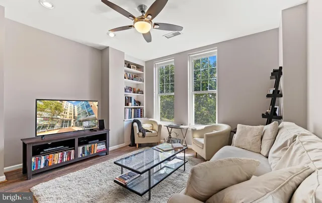 a living room with furniture a flat screen tv and a large window