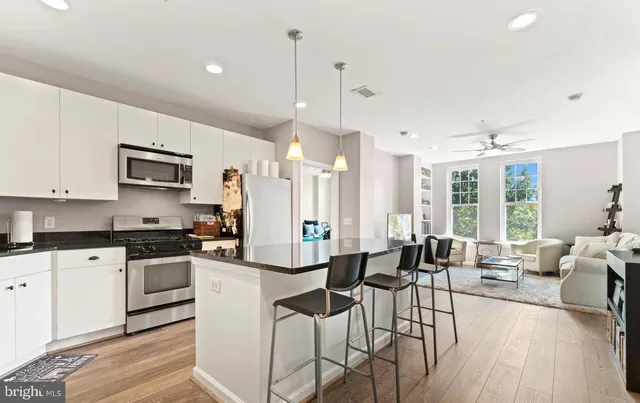 a large kitchen with cabinets table and chairs