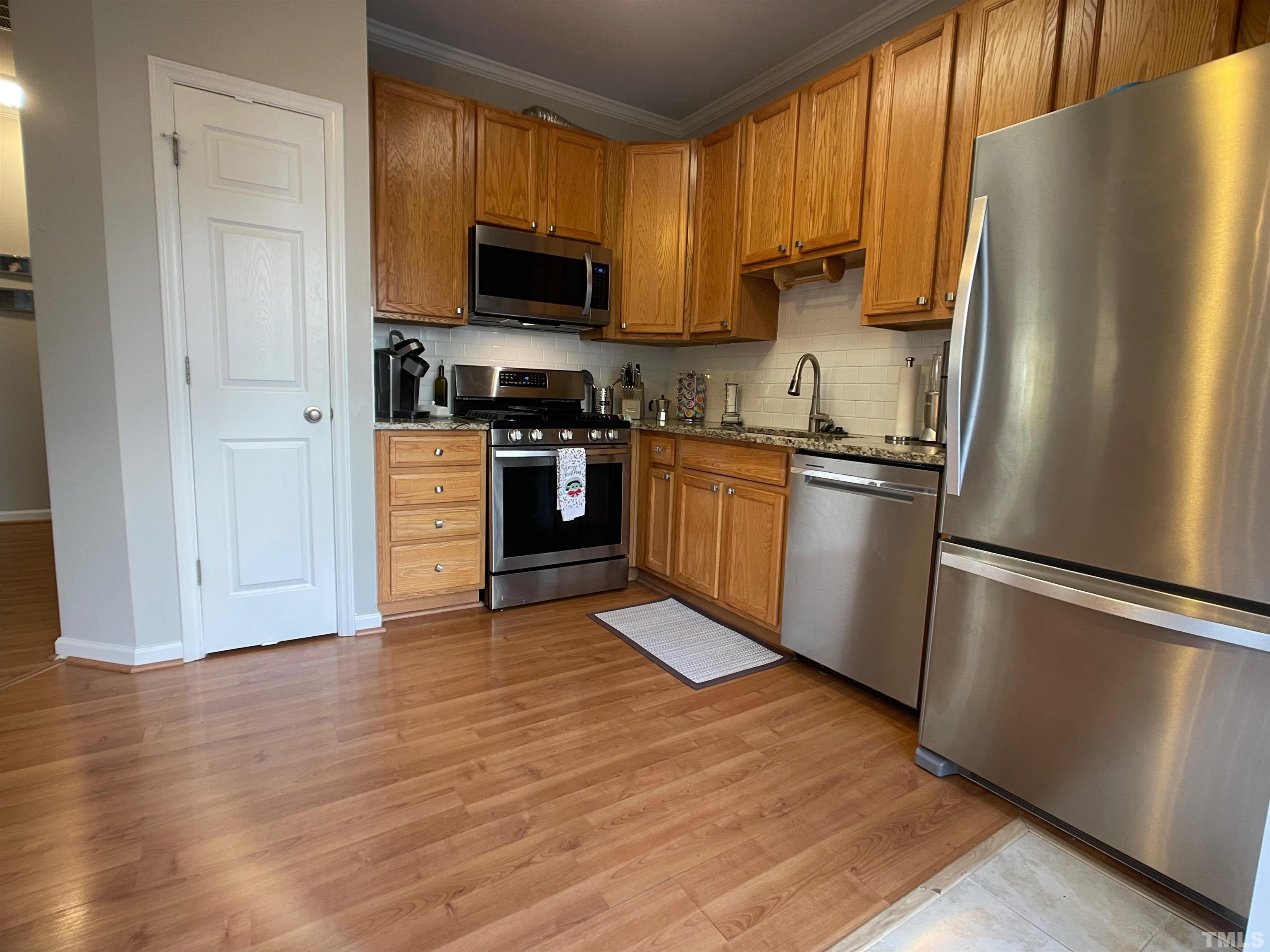 11710 Mezzanine Drive, Unit 101 Raleigh, NC 27614 - Photo 8 of 23 a kitchen with stainless steel appliances granite countertop a refrigerator stove a sink dishwasher and microwave