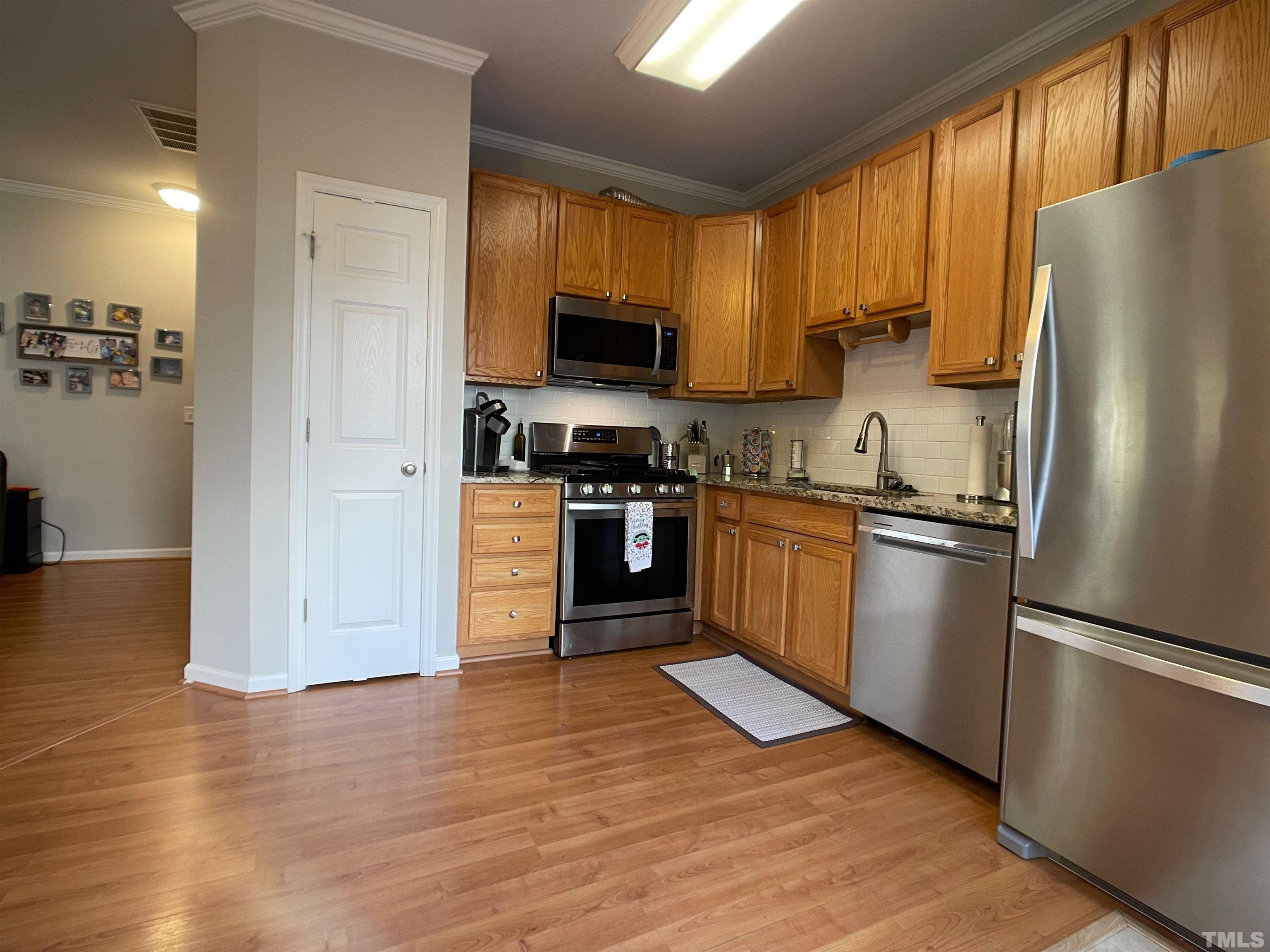 11710 Mezzanine Drive, Unit 101 Raleigh, NC 27614 - Photo 9 of 23 a kitchen with granite countertop a refrigerator stove top oven and sink