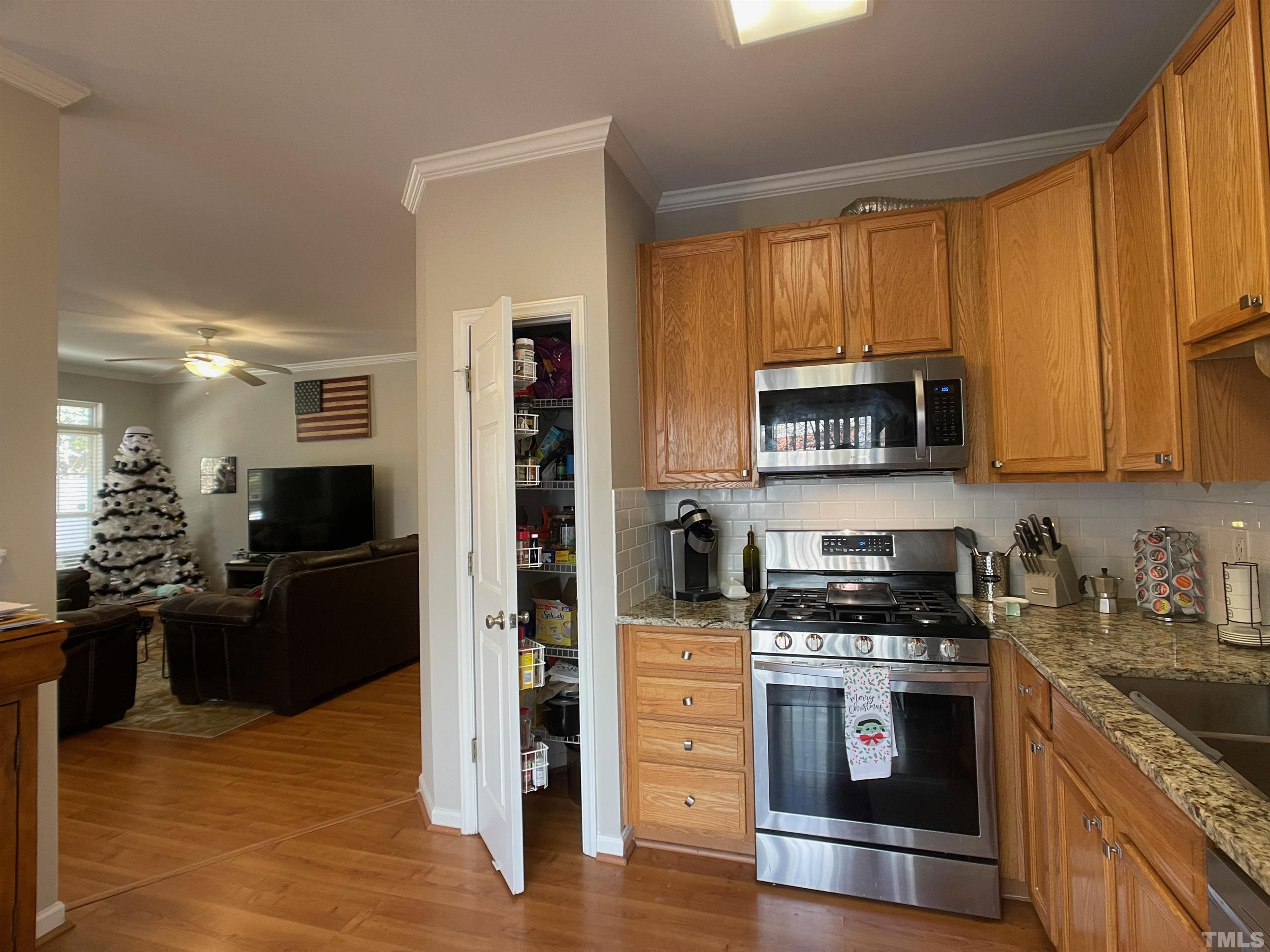 11710 Mezzanine Drive, Unit 101 Raleigh, NC 27614 - Photo 10 of 23 a kitchen with stainless steel appliances granite countertop a stove refrigerator and microwave