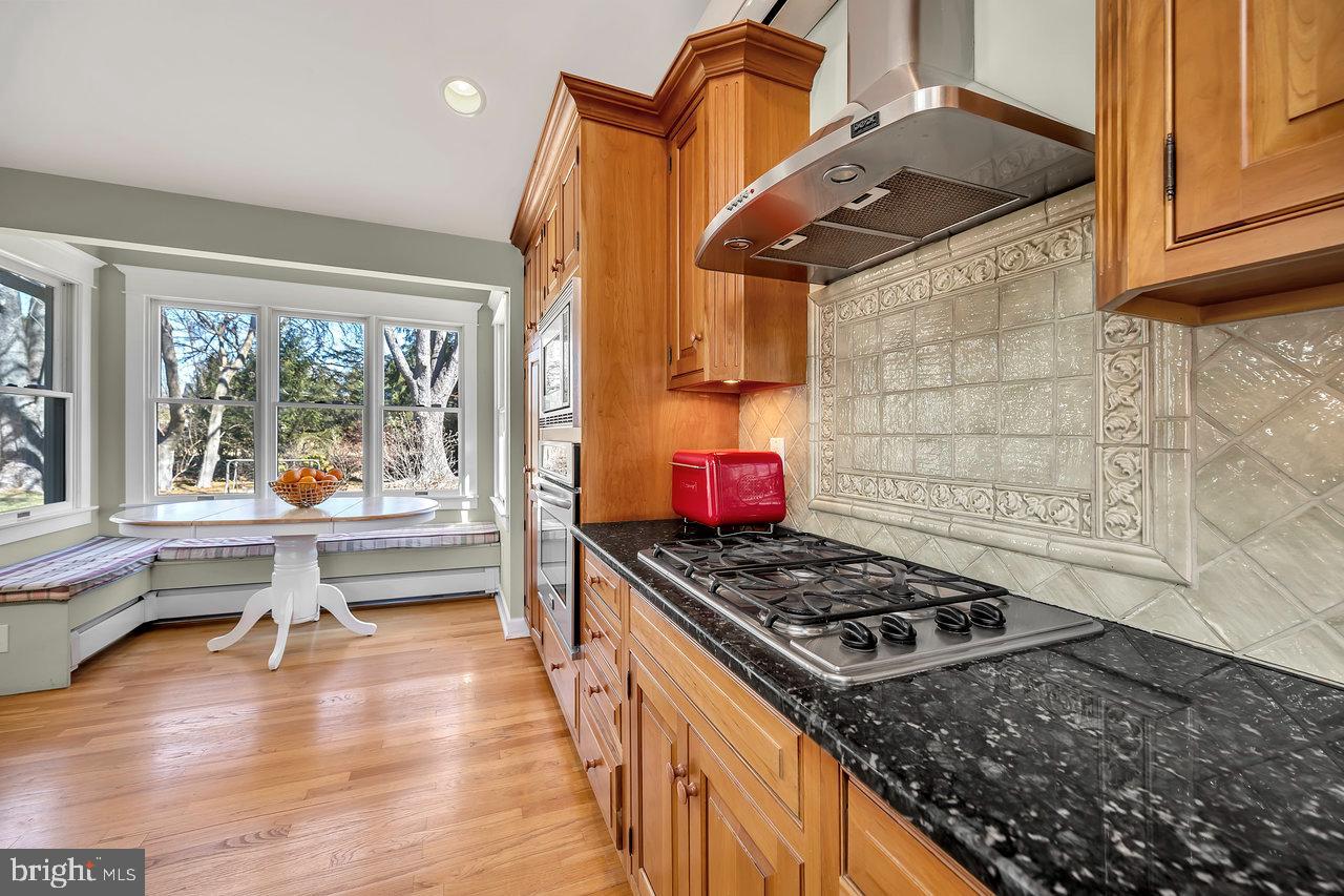 23 Griggs Road Cranbury, NJ 08512 - Photo 20 of 40 a kitchen with granite countertop a stove and a wooden floors