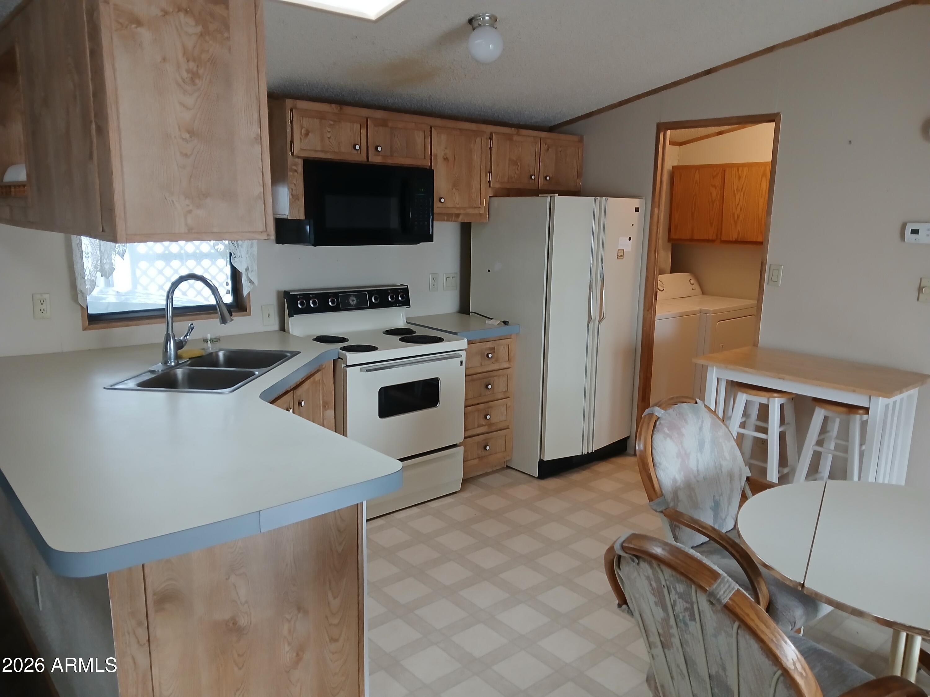834 South Meridian Road, Unit 162 Apache Junction, AZ 85120 - Photo 3 of 32 a kitchen with furniture a refrigerator and a stove