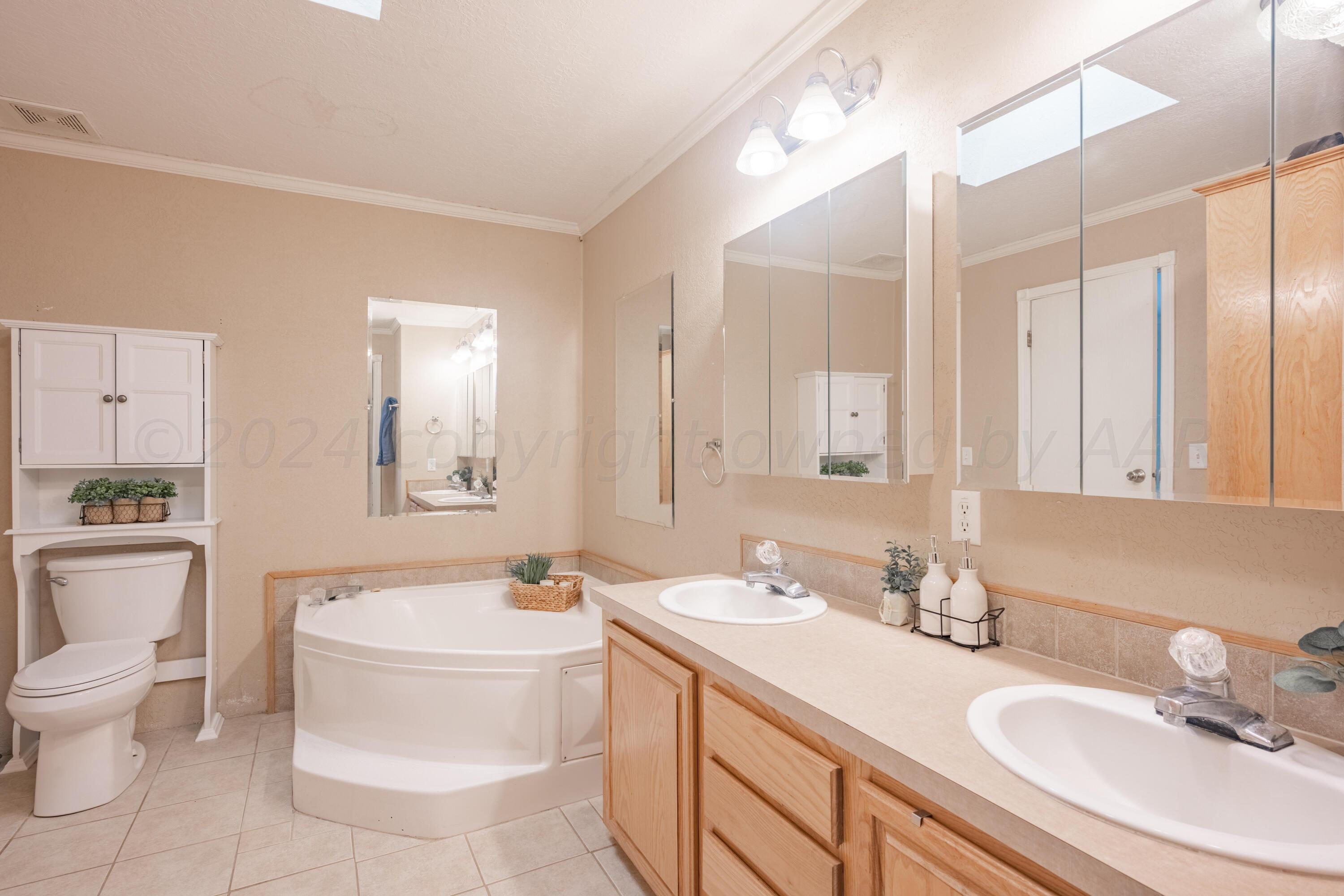 8701 Foxtail Street Amarillo, TX 79118 - Photo 18 of 33 a bathroom with a toilet sink and mirror