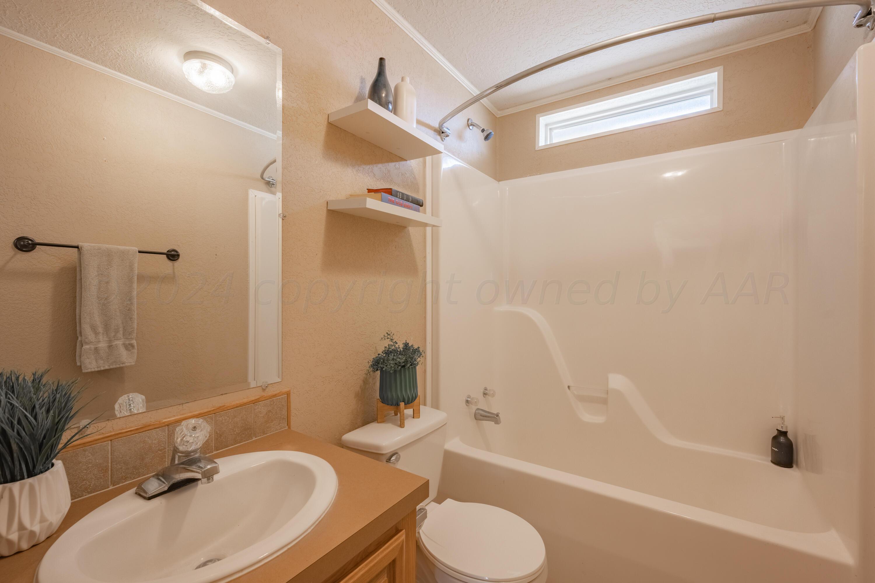 8701 Foxtail Street Amarillo, TX 79118 - Photo 24 of 33 a bathroom with a granite countertop sink toilet and shower