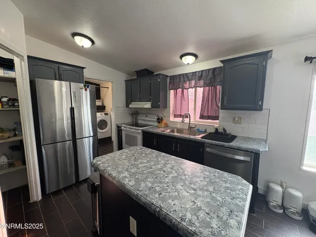 a kitchen with a refrigerator and a stove top oven