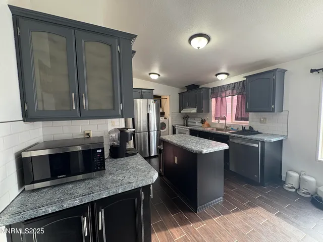 a kitchen with a sink dishwasher a stove and a microwave oven with cabinets