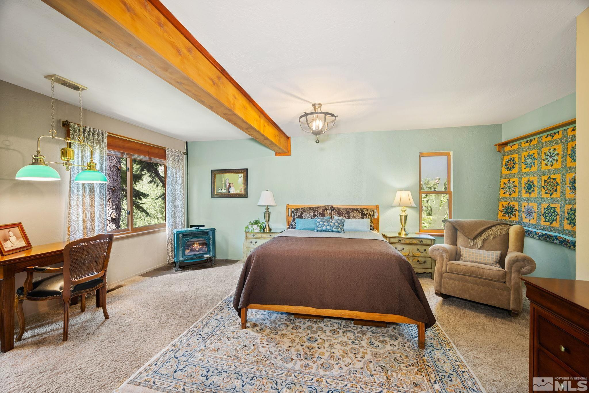 310 Barton Drive Stateline, NV 89449 - Photo 22 of 36 a bedroom with a bed a couch and a dresser next to a window