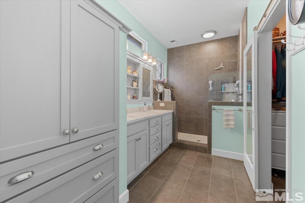 10754 Misty Meadows Drive Reno, NV 89521 - Photo 15 of 29 a bathroom with a double vanity sink a toilet and a shower