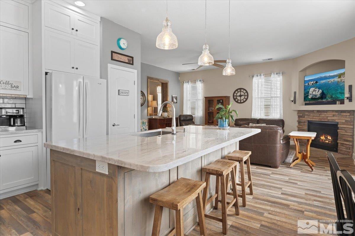 10754 Misty Meadows Drive Reno, NV 89521 - Photo 8 of 29 a kitchen with stainless steel appliances kitchen island granite countertop a table chairs and a refrigerator