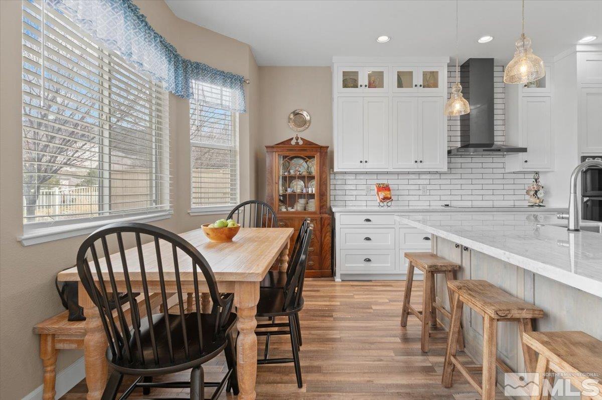 10754 Misty Meadows Drive Reno, NV 89521 - Photo 9 of 29 a kitchen that has a table chairs in it and wooden floors