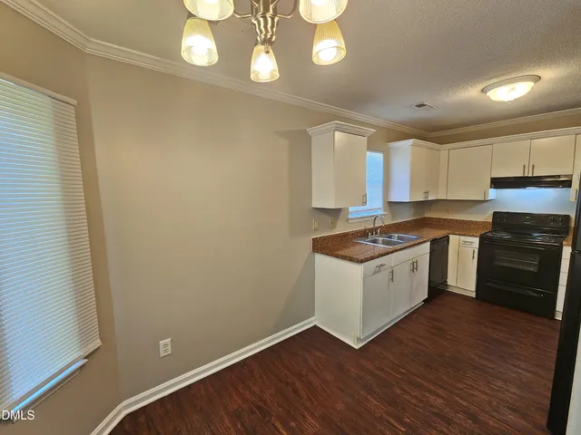 a kitchen with granite countertop a refrigerator stove and sink