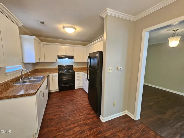 a large kitchen with a stove a sink and a refrigerator