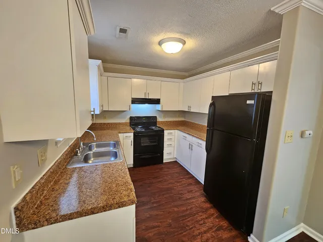 a kitchen with a refrigerator stove and wooden cabinets